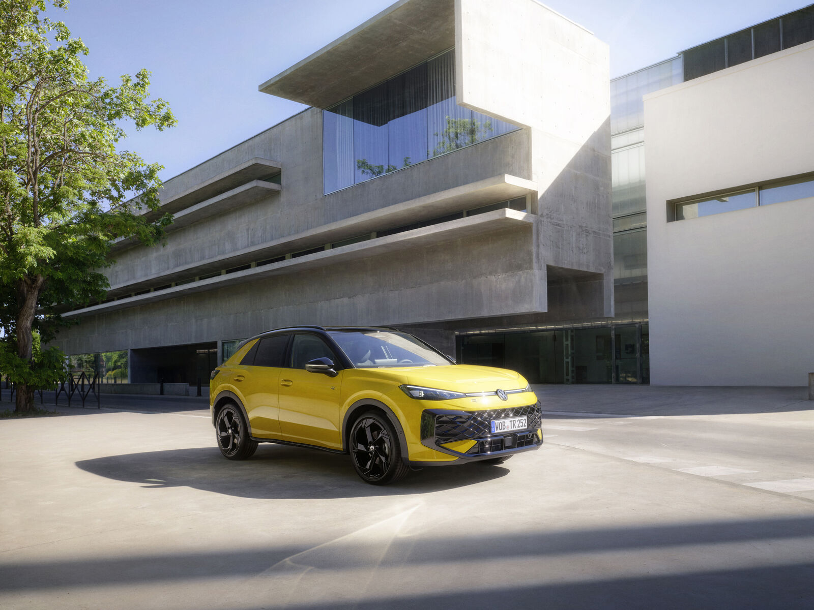 Yellow second-generation Volkswagen T-Roc outside a modern building in an official Volkswagen press image